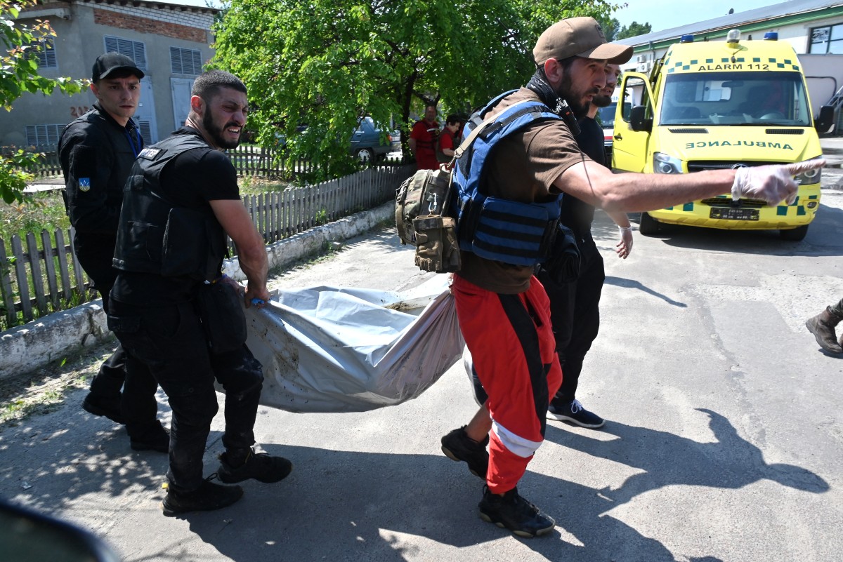 متطوعون وطاقم طبي يحملون جثة شخص قُتل خلال هجوم صاروخي في خاركيف. المصدر: AFP