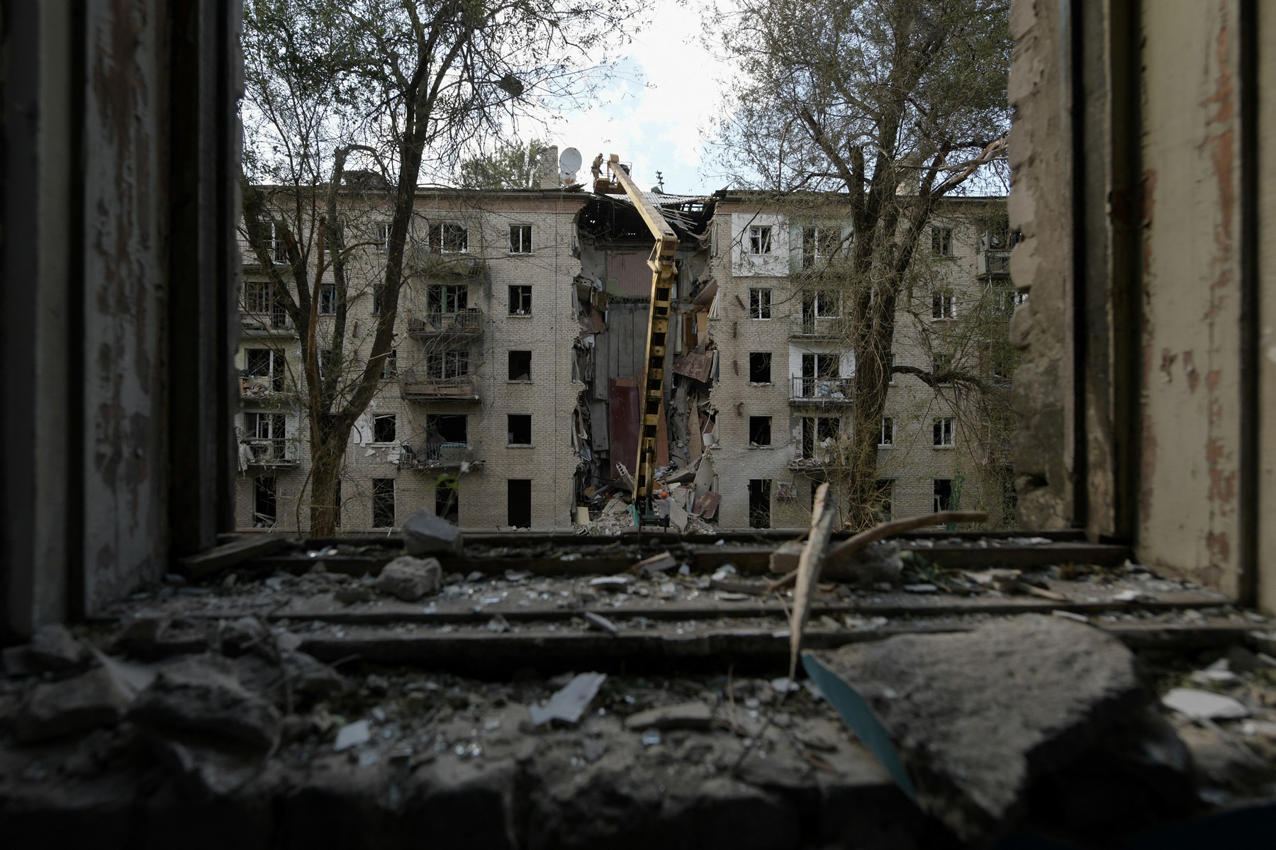 عمال الإنقاذ يزيلون أنقاض مبنى سكني مدمر في لوغانسك. المصدر AFP