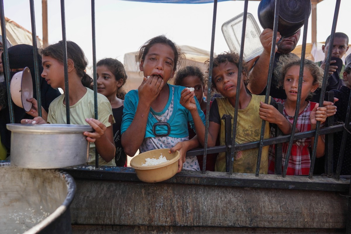 "فلسطينيون يتلقون حصص الطعام في مخيم إيواء مؤقت في خان يونس، غزة، 3 سبتمبر 2024"
 / AFP