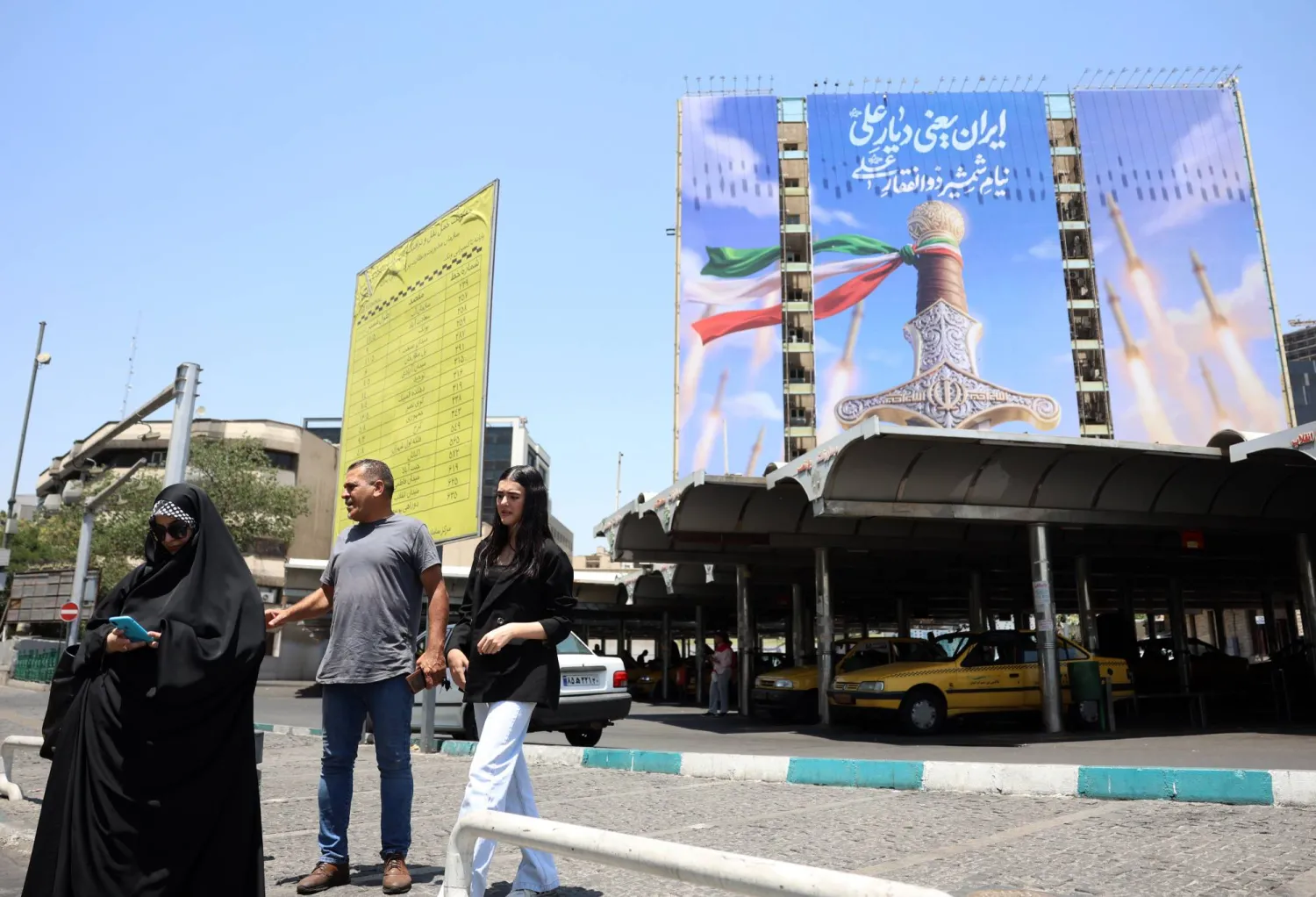 إيرانيون يمرون أمام لوحة إعلانية سياسية في طهران - إيران 11 يونيو 2026