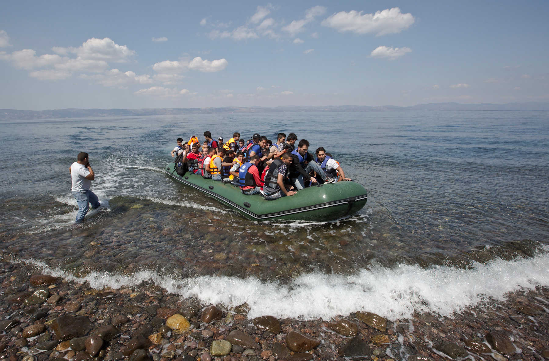 Syrian migrants after reaching the shore of Eftalou beach, 60 kilometers north of the port town of Mytilini after crossing the Aegean from Turkey on the southeastern Greek island of Lesbos, Greece, Sunday, Aug. 23, 2015. Greece this year has been overwhelmed by record numbers of migrants arriving on its eastern Aegean islands, with more than 160,000 landing so far. (AP Photo/Visar Kryeziu)
