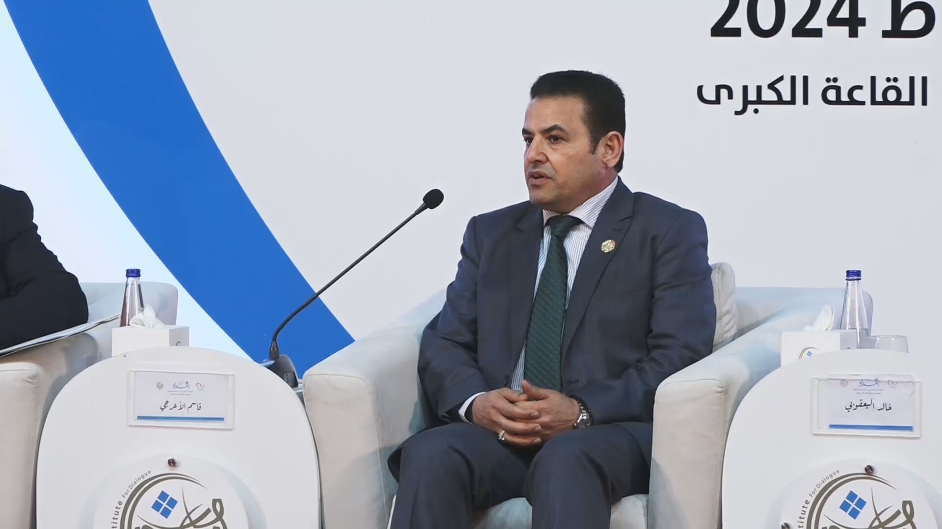 A screenshot of a video footage of Iraqi National Security Advisor Qassim al-Araji during the Sixth International Dialogue Conference in Baghdad. (Channel8)