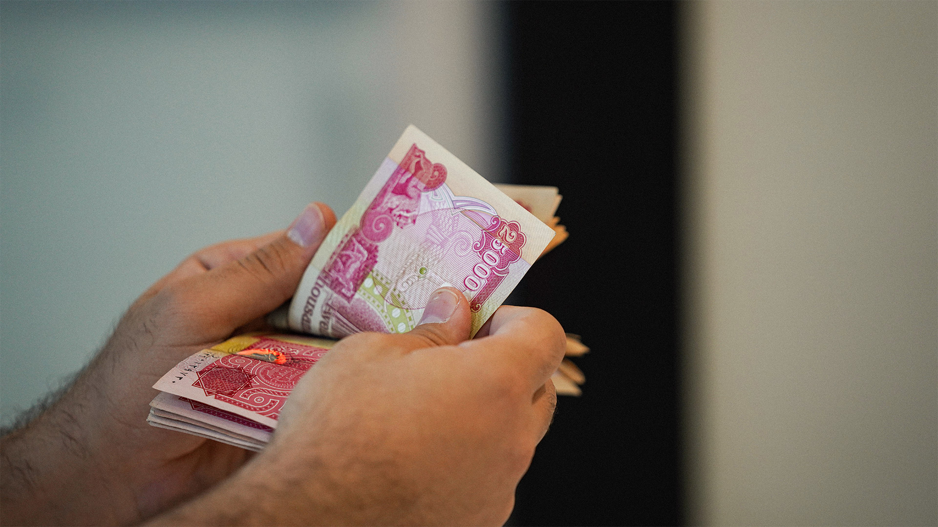 A man holding Iraqi dinar bills. (photo: Hama Sur/Channel8)