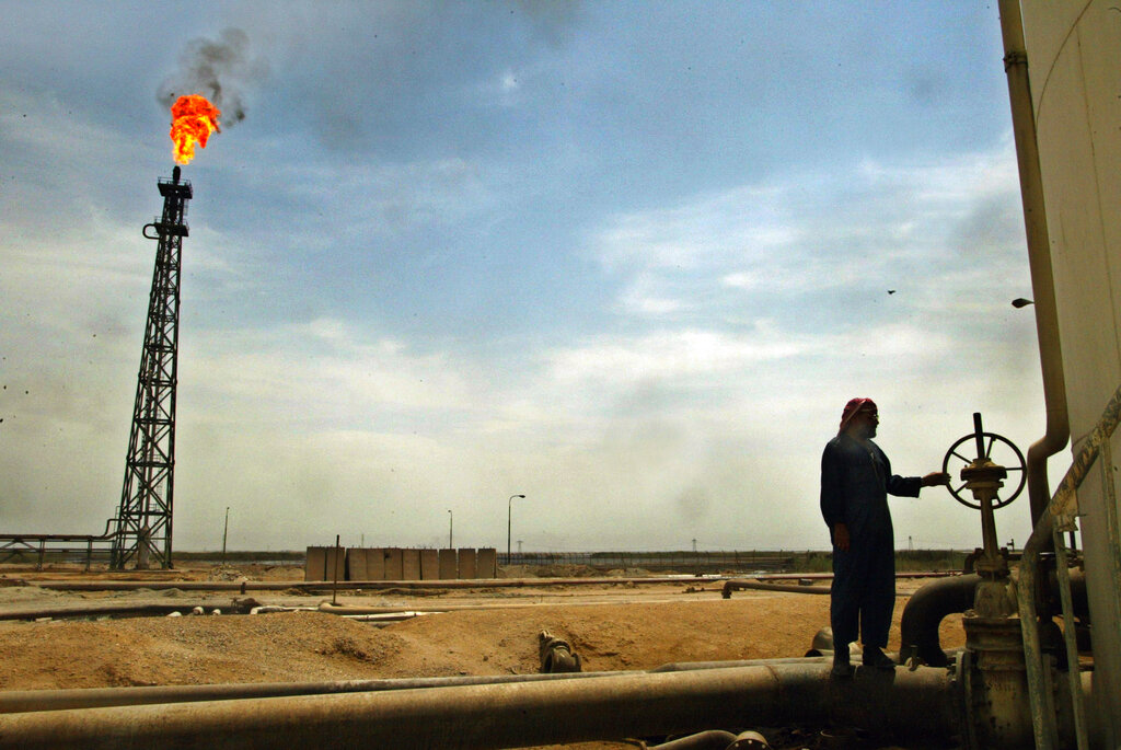 FILE - In this May 14, 2003 file photo, an Iraqi oil worker tends to his work at the Basra Oil refinery in southern Iraq. Iraq's oil ministry says the country's oil reserves are significantly higher than current estimates of 115 billion barrels. (AP Photo/Elizabeth Dalziel, File)