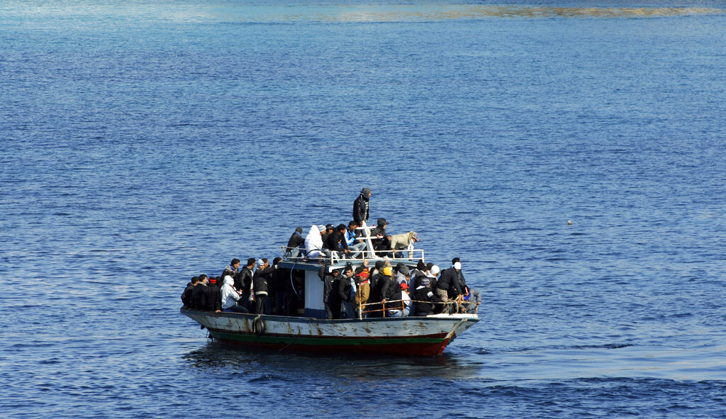 A boatload of would-be migrants believed to be from North Africa is seen moments before being rescued by the Italian Coast Guard in the waters off the Sicilian island of Lampedusa, Italy, Sunday, Feb. 13, 2011. Photo: AP