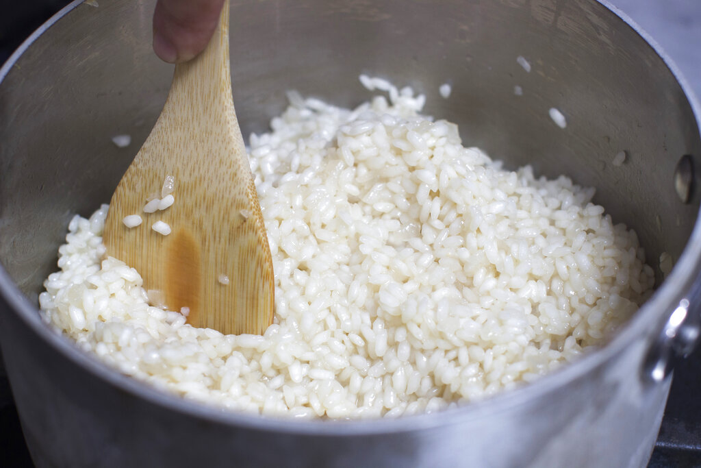 In this Sept. 29, 2014 photo broth is stirred into risotto in Concord, N.H. Like omelets or tortillas, risotto is attractive as a weeknight dinner because of its flexibility. (AP Photo/Matthew Mead)