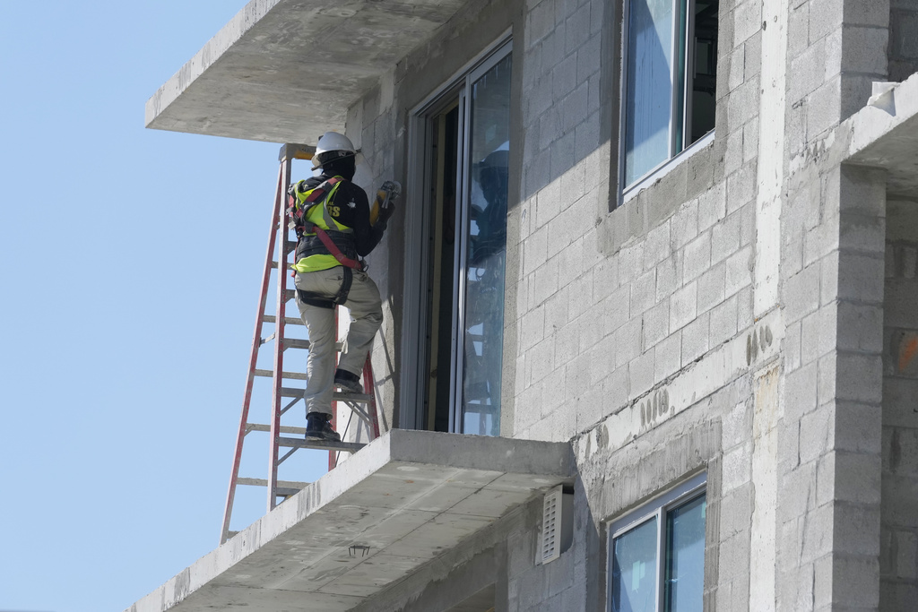 A construction worker sands a door opening at a new apartment complex, Tuesday, February 28, 2023, in Miami.  (AP Photo/Marta Lavandier)