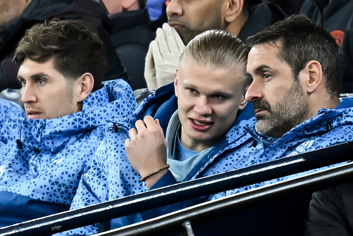 Manchester City's English defender #05 John Stones and Manchester City's Norwegian striker #09 Erling Haaland (C) sit in the stands as they watch the English Premier League football match between Manchester City and Aston Villa at the Etihad Stadium in Manchester, north west England, on April 3, 2024. (Photo by Paul ELLIS/AFP) 
