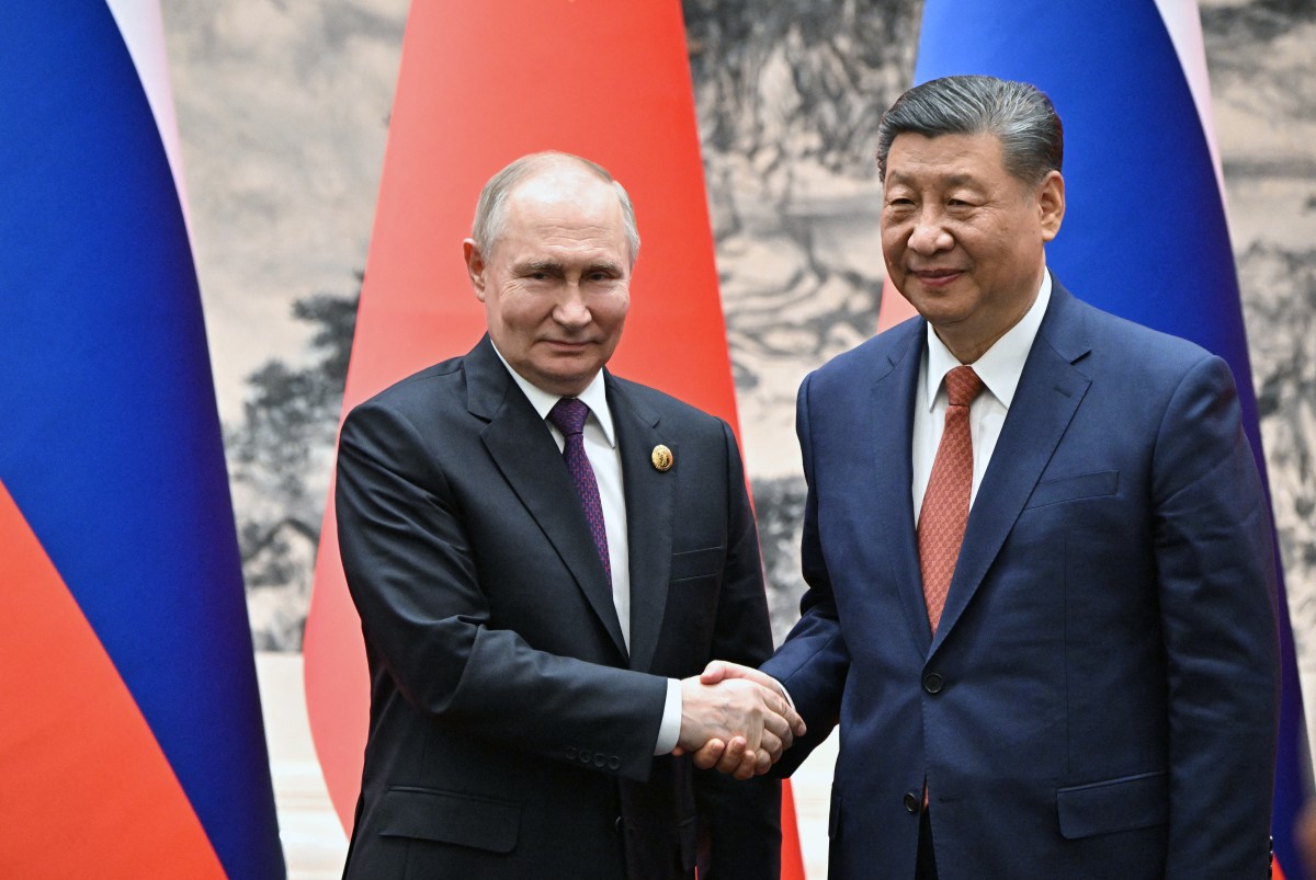 In this pool photograph distributed by the Russian state agency Sputnik, Russia's President Vladimir Putin (L) and China's President Xi Jinping shake hands during their meeting in Beijing on May 16, 2024. Photo: AFP 