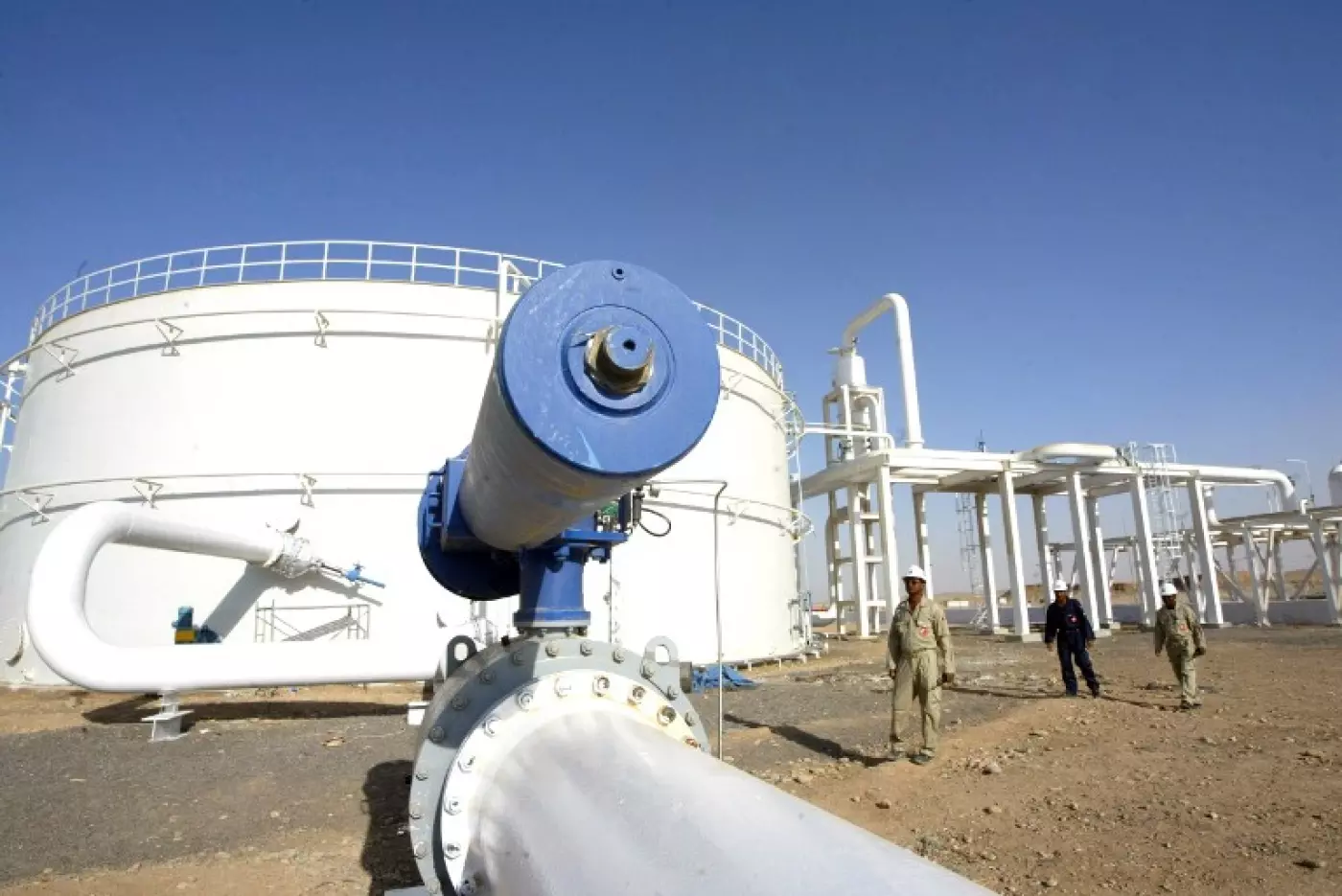 Engineers walk in the grounds of the Khurmala oilfield near Erbil (AFP)
