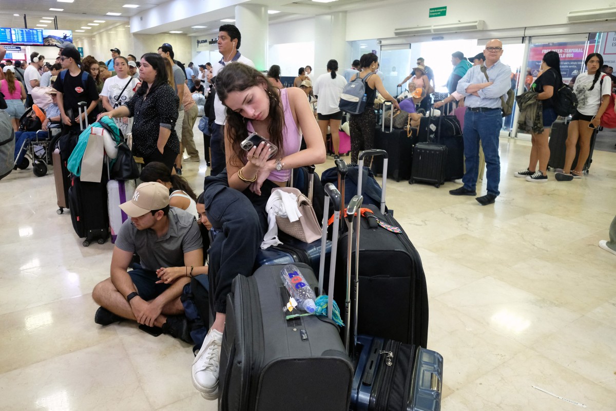 Passengers wait for their flights at the Cancun airport in Quintana Roo state, Mexico on July 19, 2024. - Airlines, banks, TV channels and other businesses were disrupted worldwide on Friday following a major computer systems outage linked to an update on an antivirus program. (Photo by ELIZABETH RUIZ / AFP)