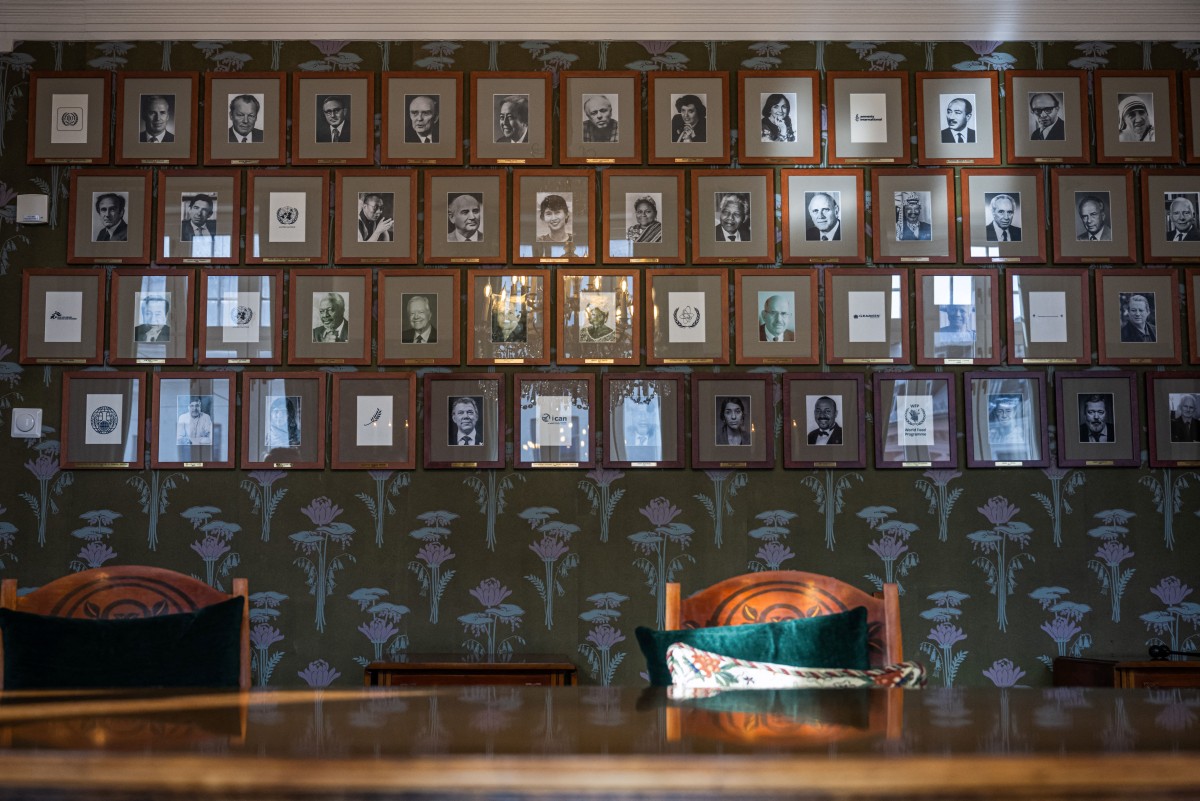 A photo taken on September 25, 2024 shows portraits of individual laureates and the logos of prize-winning institutions and organisations on a wall of the committee meeting room at the Norwegian Nobel Institute in Oslo, Norway. 
