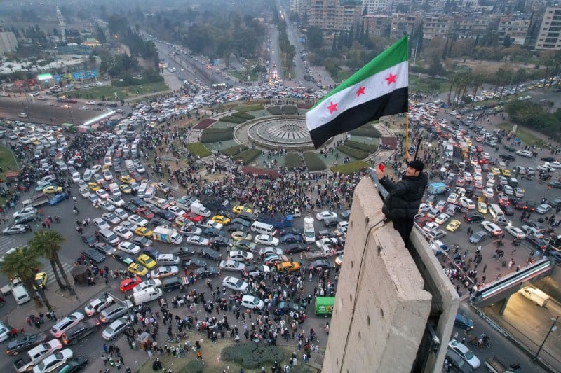 An aerial view shows a Syrian man waving the independence-era Syrian flag over the central Umayyad Square in Damascus on Dec. 11. Bakr Alkasem/AFP via Getty Images