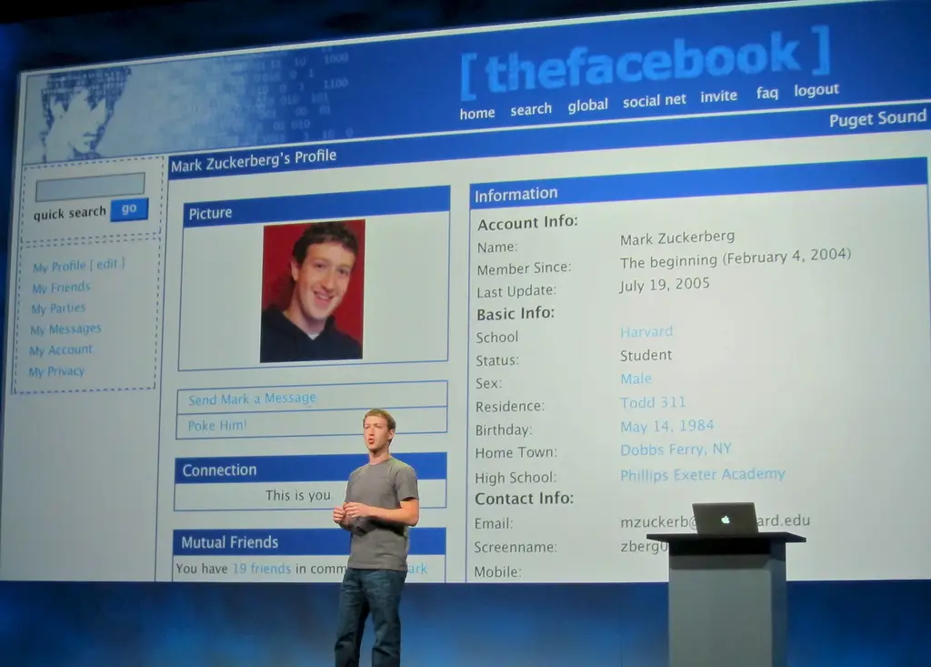 Facebook founder Mark Zuckerberg speaking in front of an image of his original Facebook profile. 