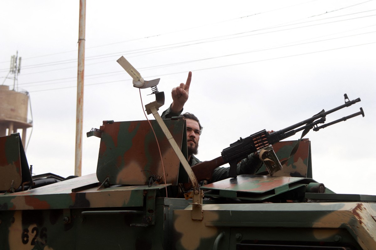 A member of Syria's security forces gestures from an armored vehicle in Sanamayn, Daraa, during a large-scale military campaign on March 5, 2025. Photo: AFP / Bakr Alkasem