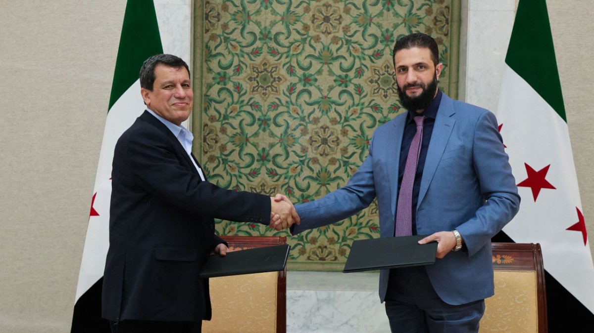 Syria's interim President Ahmed al-Sharaa (R) and SDF Commander-in-Chief Mazloum Abdi shake hands after signing an integration agreement in Damascus on March 10, 2025. Photo: SANA / AFP 