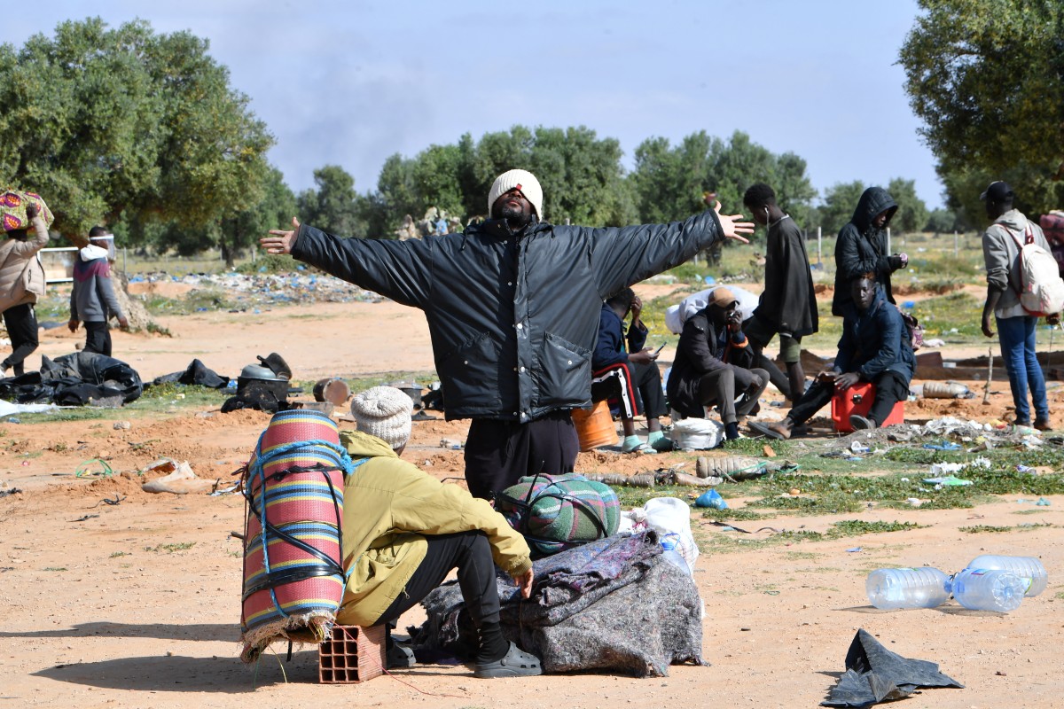Migrants gather their belongings as they leave a camp for undocumented migrants from sub-Saharan Africa at al-Amra on the outskirts of the Tunisian port city of Sfax on April 5, 2025, after authorities started dismantling the camp. (Photo by FETHI BELAID / AFP)
