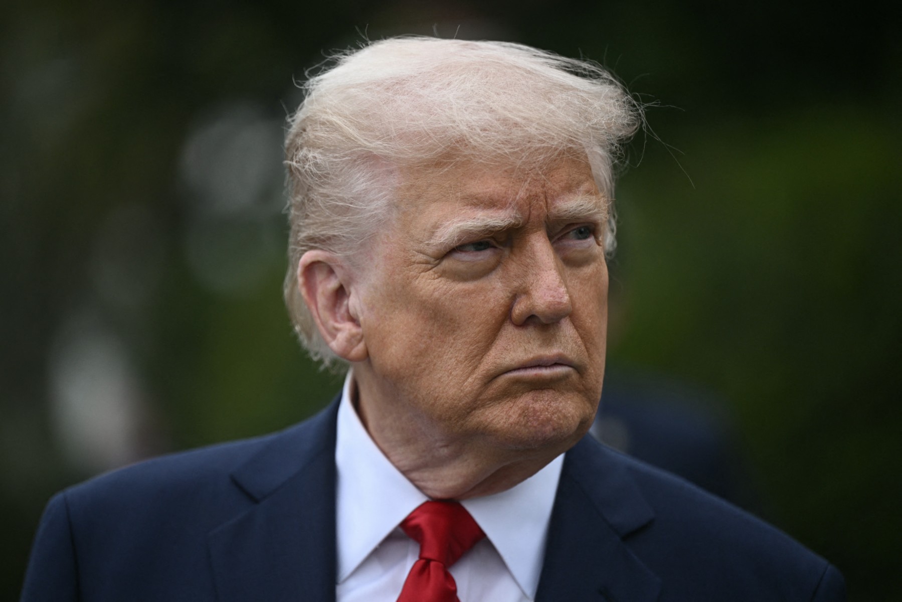 US President Donald Trump looks on as he hosts the annual Easter Egg Roll on the South Lawn of the White House on April 21, 2025, in Washington, DC. According to the US National Park Service, the egg roll tradition dates back to 1878 when President Rutherford B. Hayes invited children to roll Easter eggs on the White House grounds. Children previously rolled eggs down a hill at the US Capitol in the early 1870s, but a law was passed in 1876 forbidding the Capitol property from being used due to the toll on the lawn. (Photo by Brendan SMIALOWSKI / AFP)