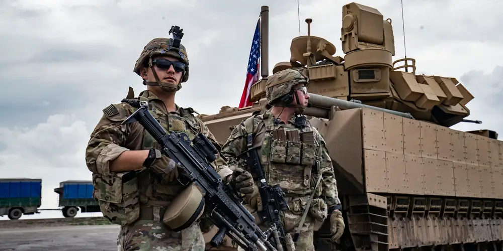US Army troops stand by an armored vehicle on the outskirts of al-Hasakeh province, Rojava, March 27, 2023.
