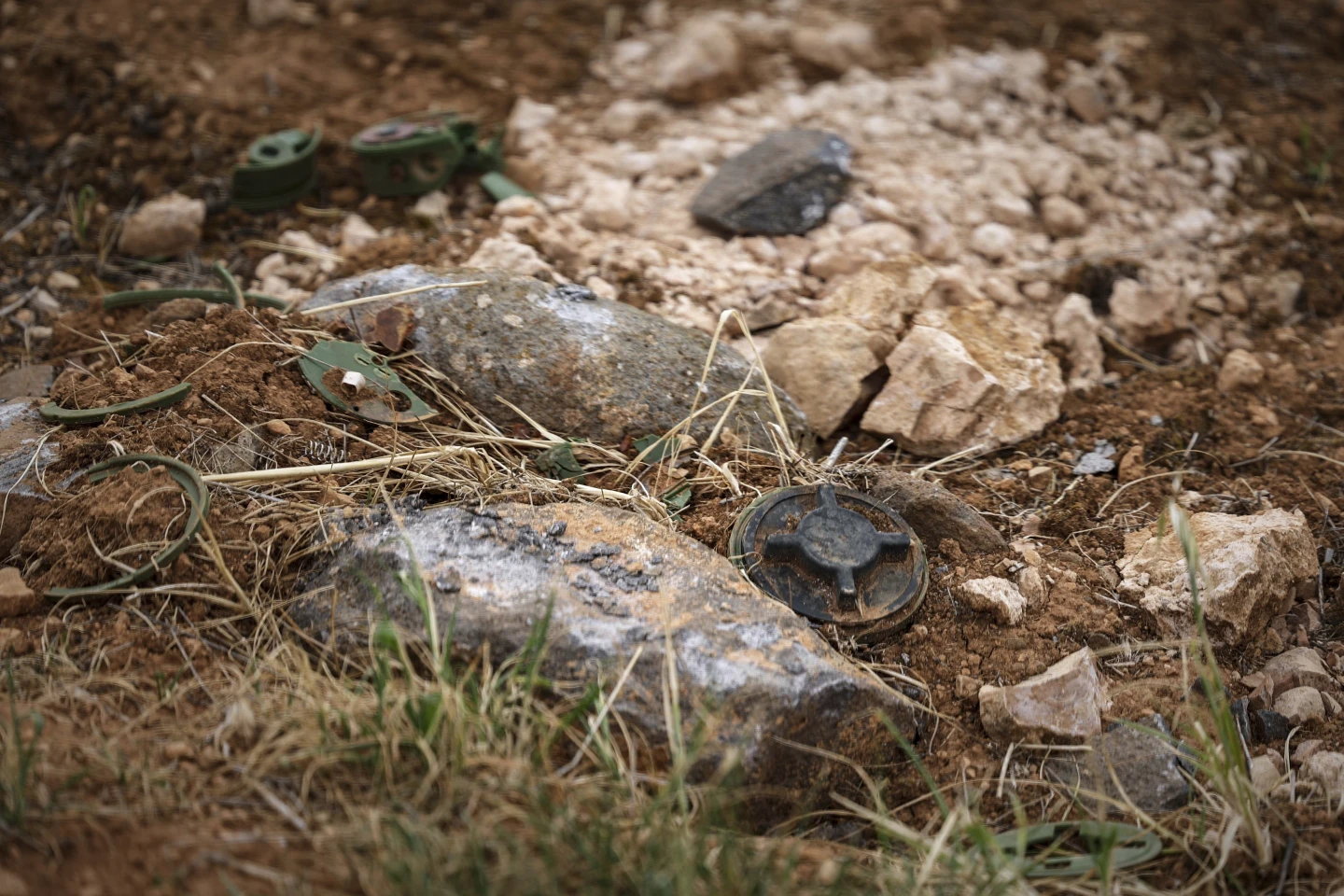Landmines in a field during a Ministry of Defense operation to clear explosives left by the Syrian army south of Idlib, Syria, April 13, 2025. Photo: Ghaith Alsayed / AP 

