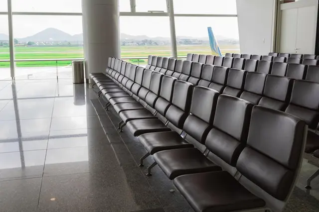 Chairs, benches, Seat Waiting lined for Departure passengers in airport and the taxi way and runway back ground.
Getty Images/Getty Images