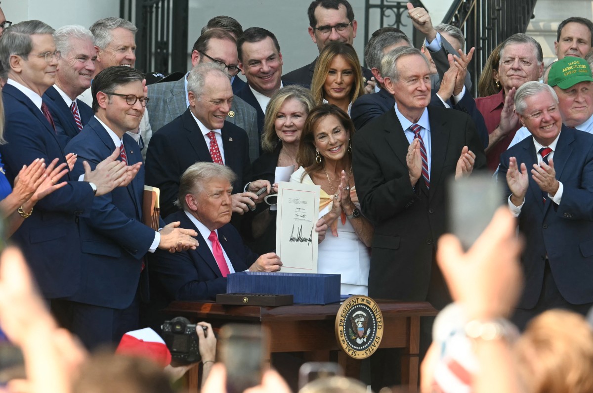 Trump shows the signed “Big Beautiful Bill” at the White House on July 4, 2025. Photo: Jim Watson / AFP