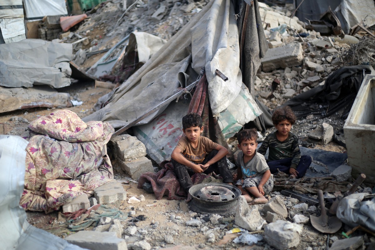 Palestinian children sit amid the destruction in the aftermath of an Israeli strike in the Bureij refugee camp in the central Gaza Strip on July 10, 2025. (Photo by Eyad BABA / AFP)