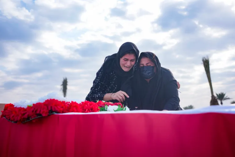 Relatives pay respects to the deceased Yazidi victims. Photo: Hadi Mizban / AP

