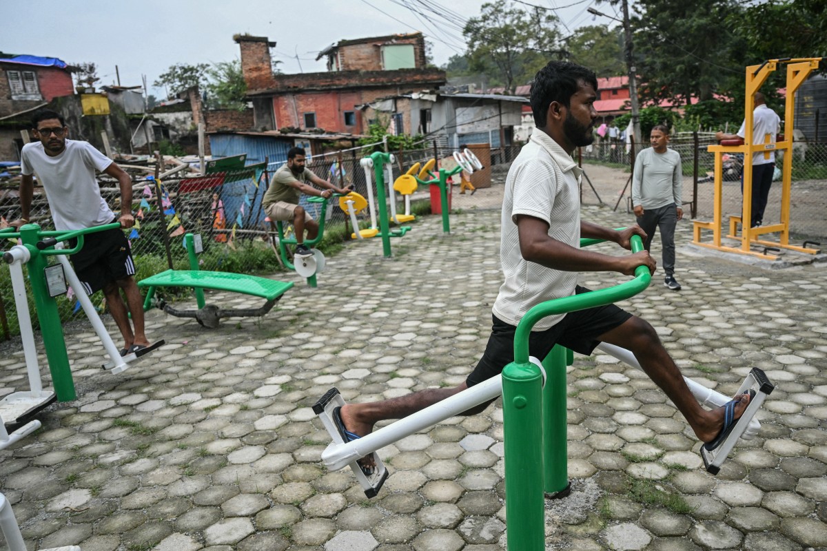 People exercise at a park in Kathmandu on September 14, 2025. The capital Kathmandu took a step back towards normality on September 13 as a curfew was eased and daily life returned, with markets opening, traffic returning and families visiting temples. (Photo by Arun SANKAR / AFP)