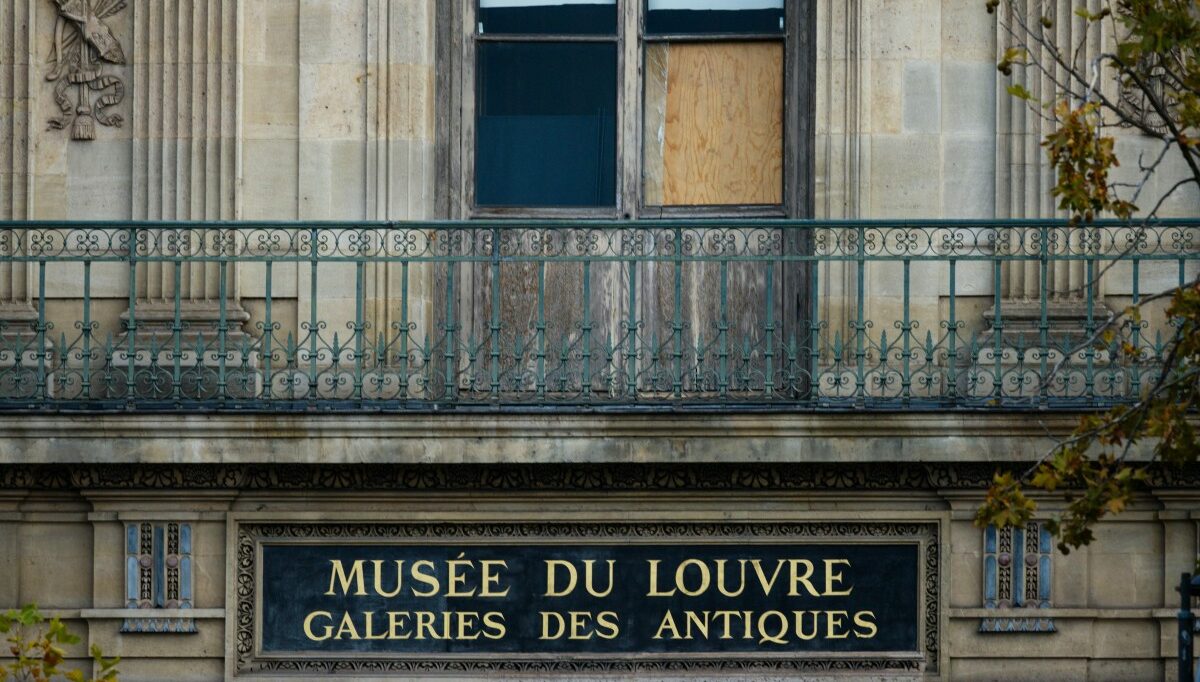 The window of the Louvre Museum is seen with the glasses covered after the thieves broke them to get in and steal priceless jewels. The museum will remain closed for the second day after the theft, in Paris on October 20, 2025. (Photo by Dimitar DILKOFF / AFP)