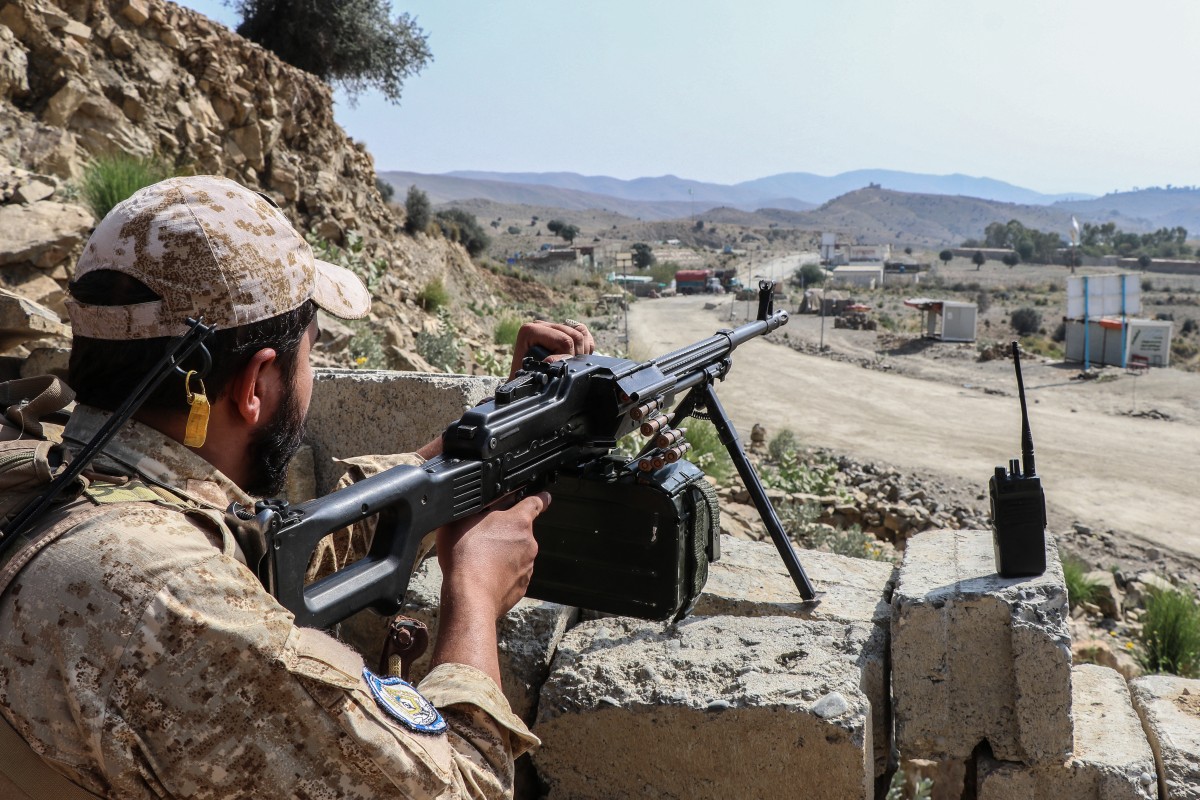 A Taliban security personnel stands guard along a road near the Ghulam Khan zero-point border crossing between Afghanistan and Pakistan in Gurbuz district in the southeast of Khost province on October 20, 2025. 