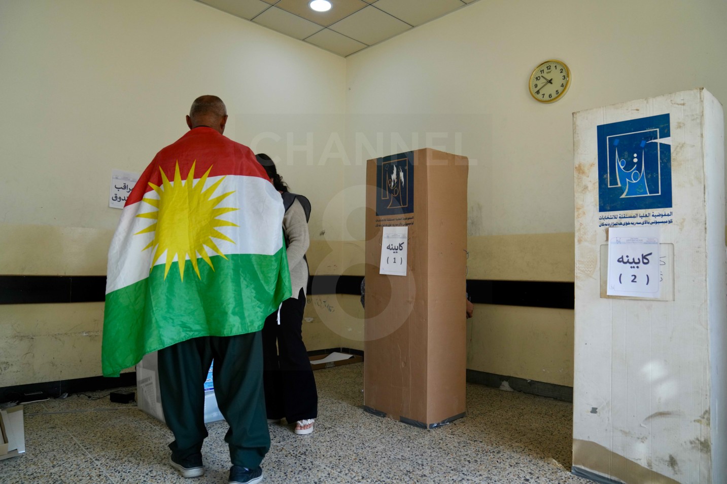 A member of the security forces, draped in the Kurdistan flag, casts his vote on November 9, 2025, during a special election for the Iraqi Parliament. Photo: Hama Sur / Channel8

