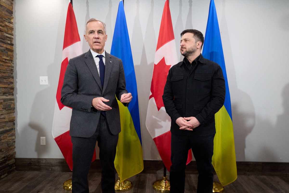 This handout photograph taken on December 27, 2025 and released by the Ukrainian Presidential Office shows Ukraine's President Volodymyr Zelensky (R) and Canadian Prime Minister Mark Carney speaking to the press as they meet in Halifax, Nova Scotia, Canada. Establishing a lasting peace in Ukraine requires "a willing Russia," Carney said Saturday, denouncing the "barbarism" of Moscow's latest bombardment of Kyiv as he met with Zelensky. (Photo by HANDOUT / UKRAINIAN PRESIDENTIAL OFFICE / AFP)  
