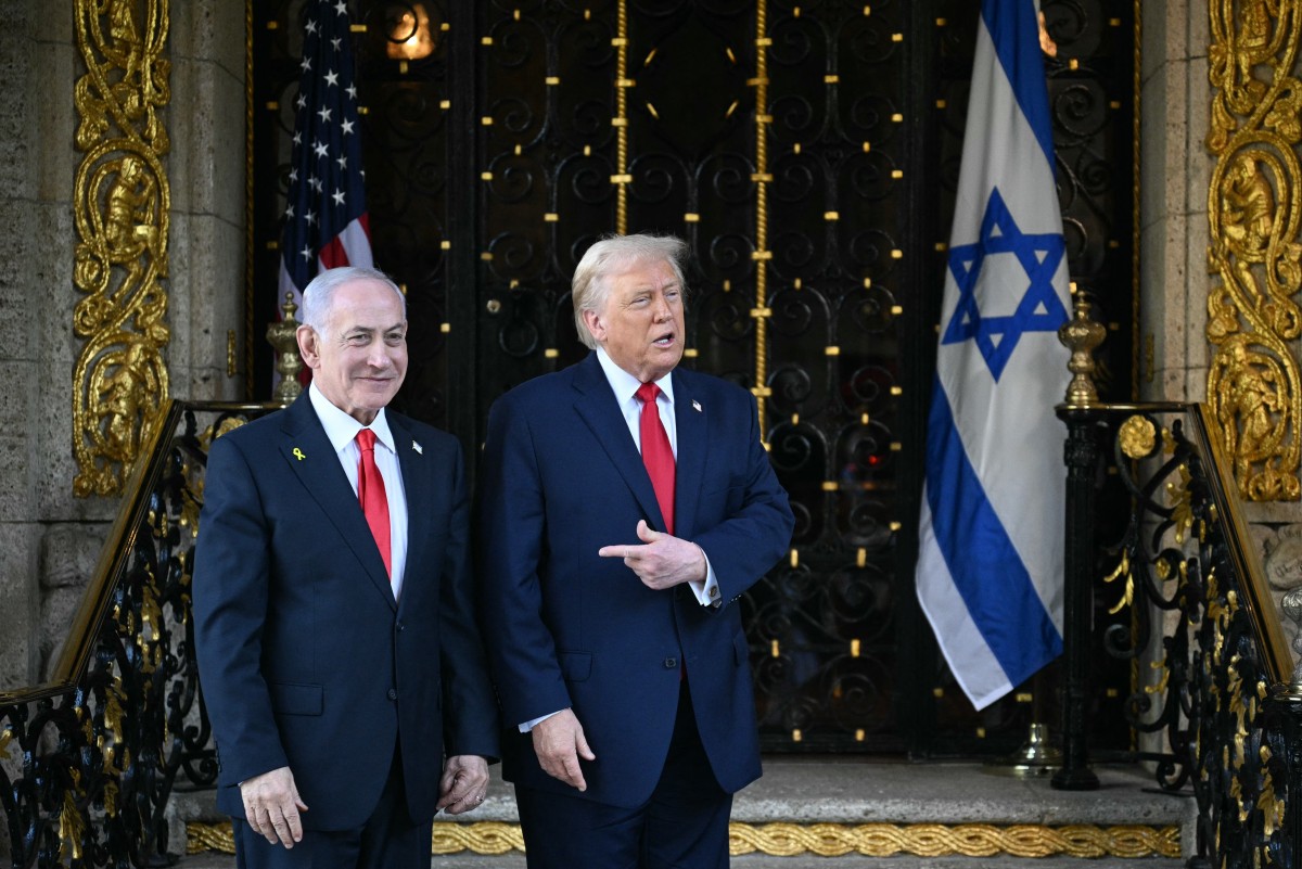 US President Donald Trump (R) greets Israeli Prime Minister Benjamin Netanyahu (L) upon arrival at Trumps Mar-a-Lago residence in Palm Beach, Florida, on December 29, 2025. (Photo by Jim WATSON / AFP)