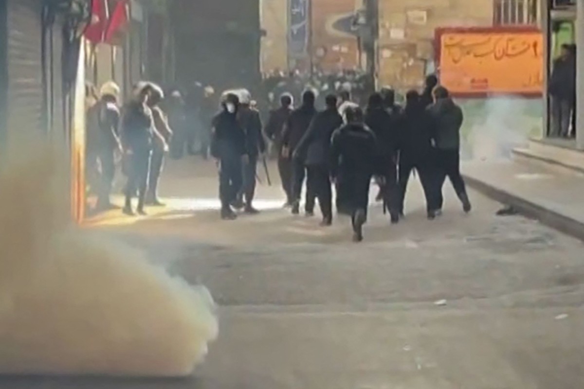 This grab taken on January 6, 2026, from UGC images posted on social media the same day shows Iranian security forces using tear gas to disperse protesters at the Tehran bazaar.
 