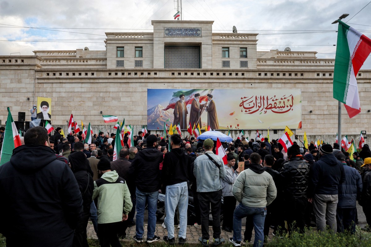 Demonstrators attend a rally organised by Lebanese political parties supporting the Hezbollah movement outside the Iranian embassy in Beirut on March 26, 2026, protesting the Lebanese government's decision to expel the Iranian ambassador to Lebanon. Lebanon's foreign ministry earlier in the week gave the Iranian ambassador until March 29 to leave the country, the latest unprecedented step by authorities since a new war erupted on March 2 between Israel and Hezbollah. Hezbollah is an armed movement backed by Iran, which also has political representation in both of Lebanon's government and parliament. (Photo by Anwar AMRO / AFP)