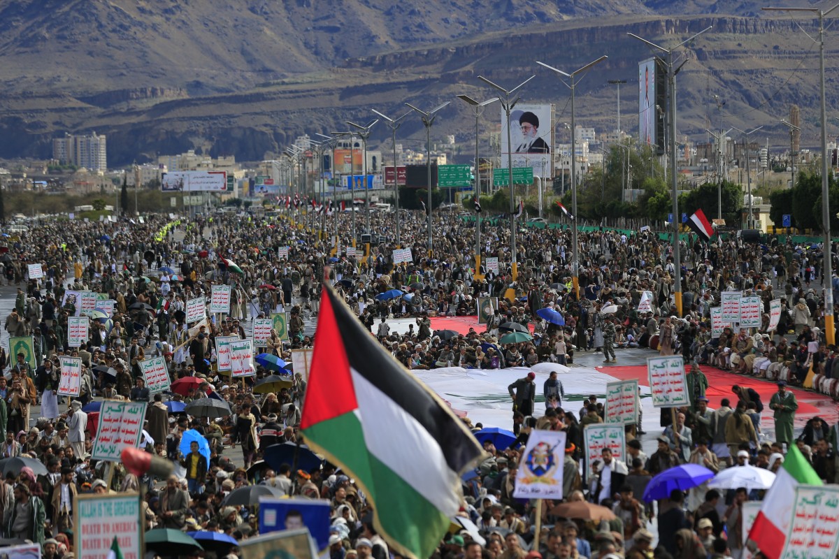A Palestinian flag is raised as Houthis rally in solidarity with Iran and Lebanon, amid the US-Israeli war with Iran, in the Yemeni capital Sanaa on March 27, 2026. Abdul Malik al-Houthi, leader of Yemen's Iran-backed Houthi movement, warned on March 26 of a "military response" should the Middle East war require it. The Houthis, a key part of Iran's so-called "axis of resistance", have so far refrained from joining the war sparked by US-Israeli strikes on Iran, which has engulfed much of the region. (Photo by Mohammed HUWAIS / AFP)