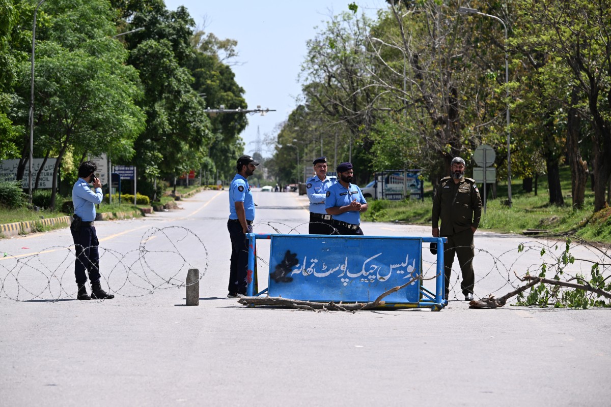 Policemen stand guard at a blocked road in the Red Zone area in Islamabad on April 9, 2026.
 