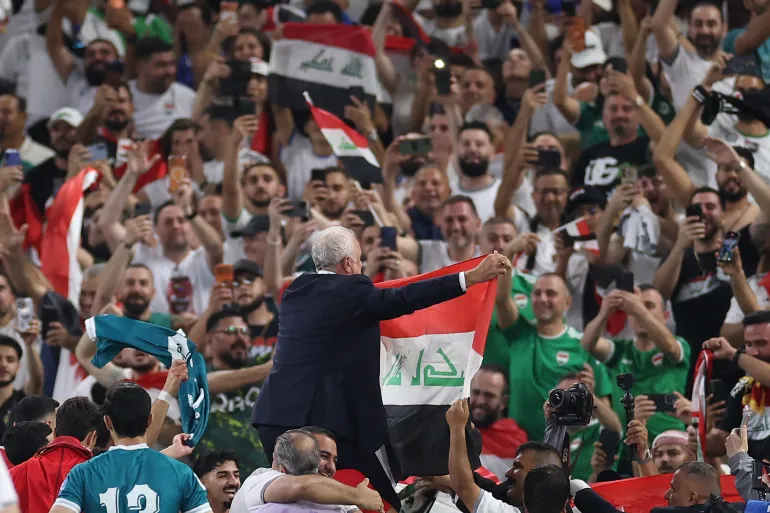 Iraq’s Australian coach Graham Arnold celebrates with the fans [Julio Cesar Aguilar/AFP]
