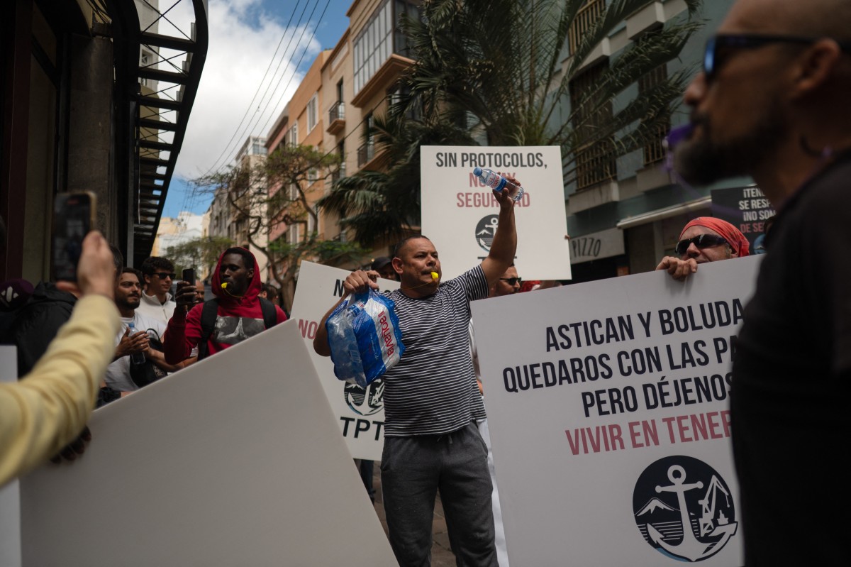 Dockers hold banners reading 'Without protocol, no safety' as they protest against the arrival of a cruise ship affected by hantavirus in Santa Cruz de Tenerife on May 8, 2026. 