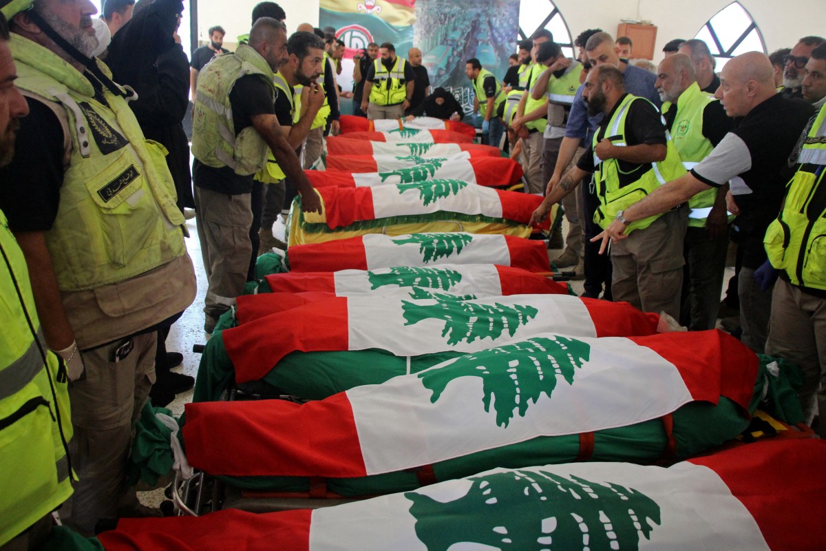 The bodies of people killed in Israeli strikes are seen wrapped in Lebanon's flags before the funeral in Tyre, southern Lebanon, on May 28, 2026. (Photo by KAWNAT HAJU / AFP)
