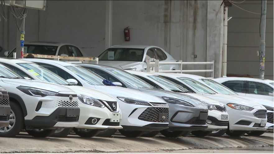 A row of cars in front of a car dealership