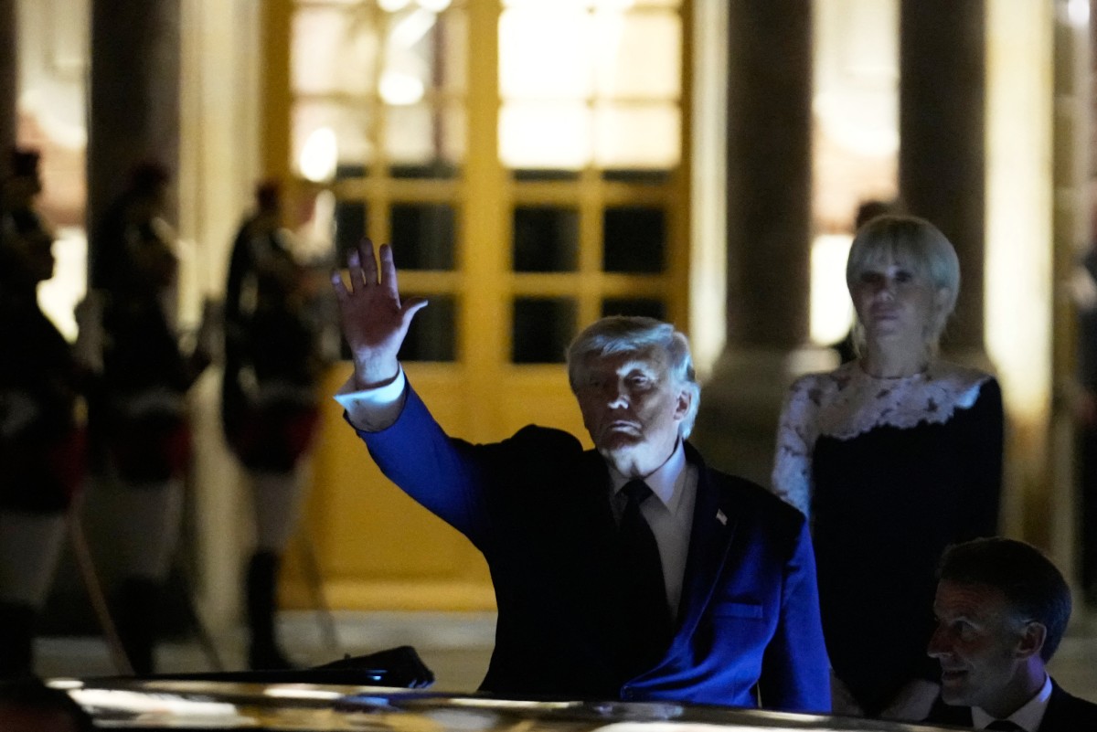 US President Donald Trump (L) walks to the presidential limousine alongside France's President Emmanuel Macron and France's First Lady Brigitte Macron following a dinner marking the 250th anniversary of US independence at the Château de Versailles in Versailles, southwest of Paris, on June 17, 2026. (Photo by Michel Euler / POOL / AFP)