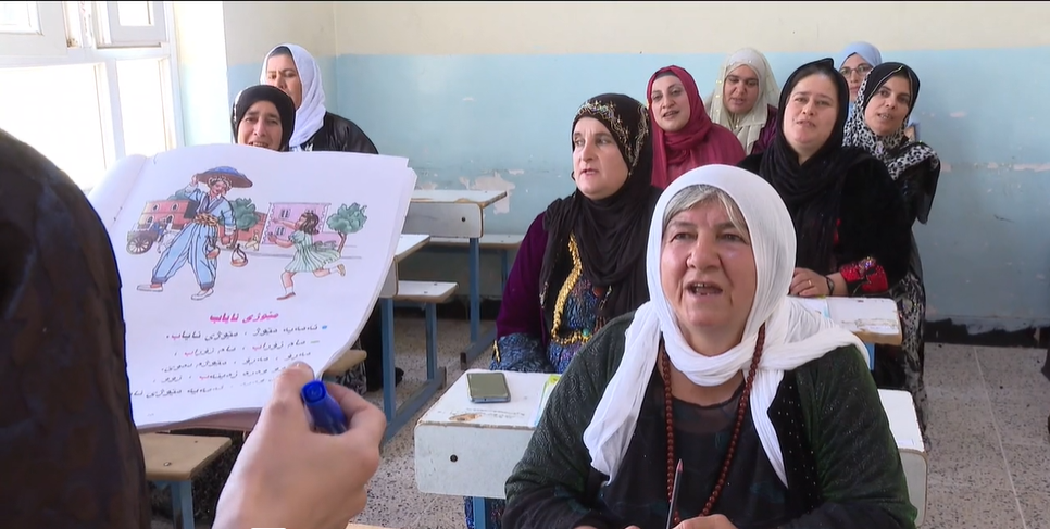 Illiterate female villagers from Askar start learning reading and writing despite age and circumstances.
