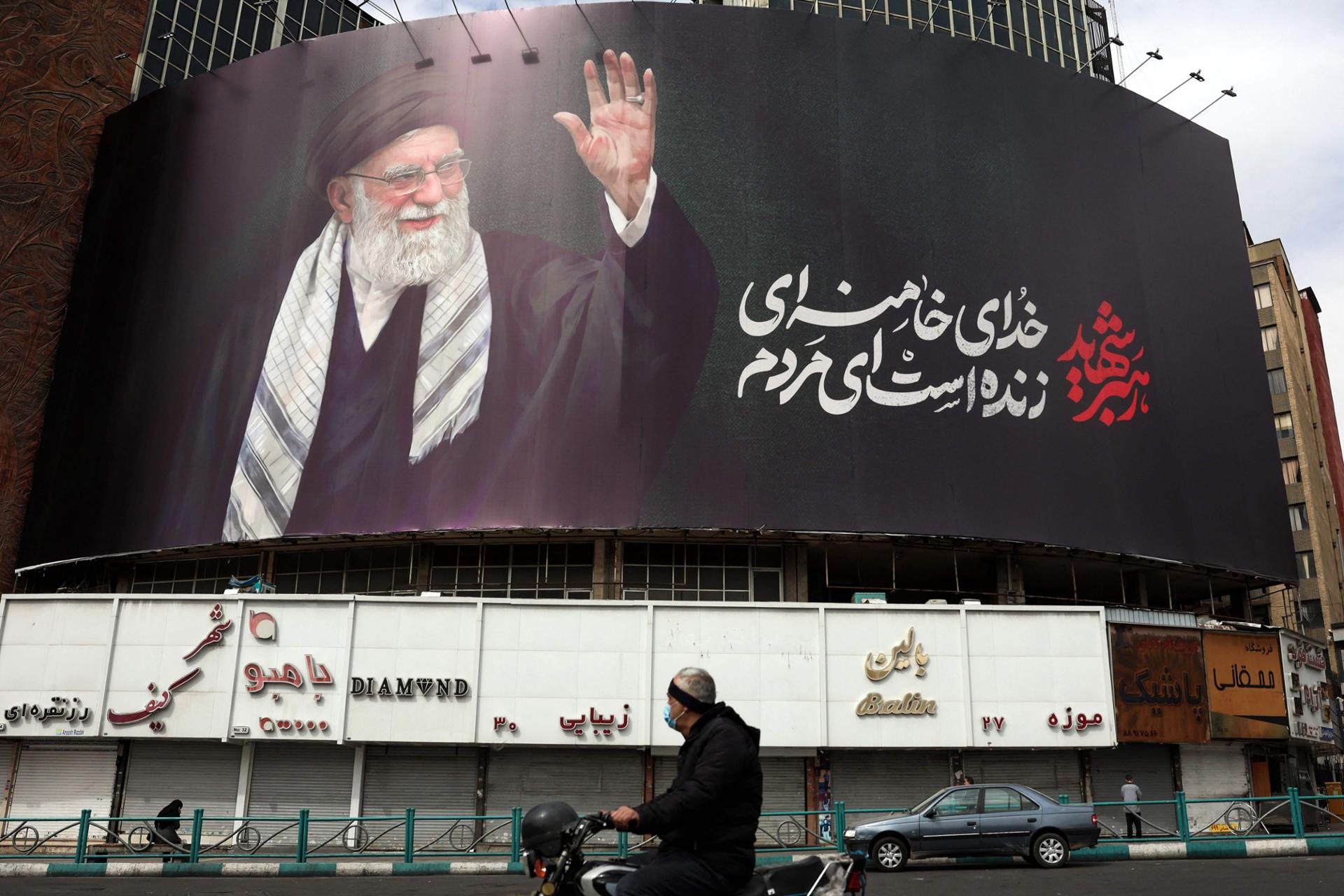 A man rides a motorbike past a billboard of Iran's supreme leader Ali Khamenei in Tehran, March 2. AFP