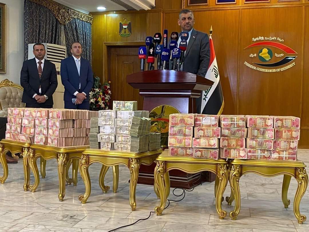 Stacks of seized Iraqi dinars and US dollars are displayed during a press conference by the Iraqi Federal Commission of Integrity (Nazaha) in Baghdad. The commission announced the recovery of the vast sums of cash, which authorities say had been prepared for money laundering.