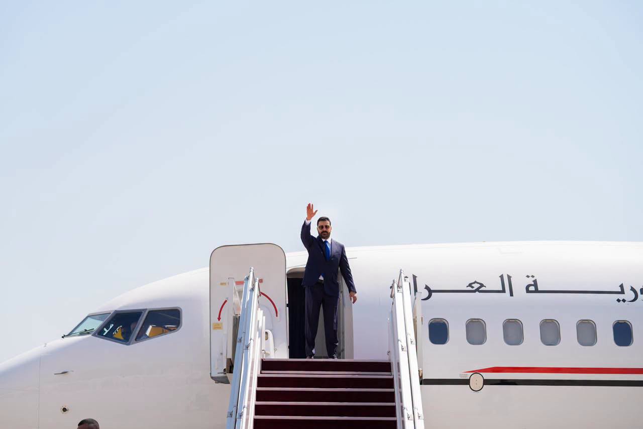 Iraqi Prime Minister  Ali al-Zaidi waves to attendees from the door of an official state aircraft prior to takeoff.