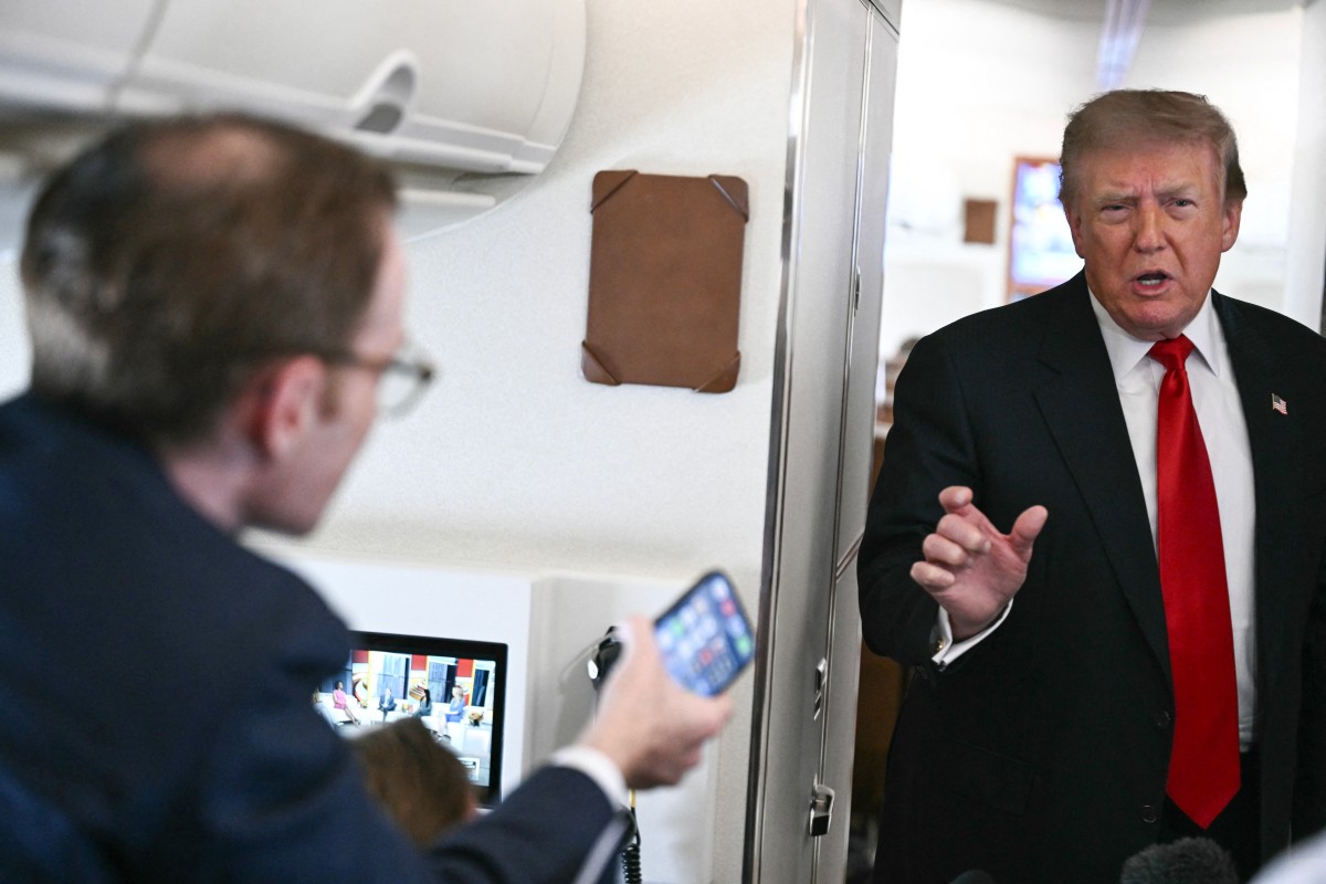 US President Donald Trump speaks to the press on board Air Force One, in the air en route to Michigan, on July 27, 2026. Trump is traveling to Milford, Michigan to deliver remarks at General Motors vehicle testing site Milford Proving Ground. (Photo by Brendan SMIALOWSKI / AFP)