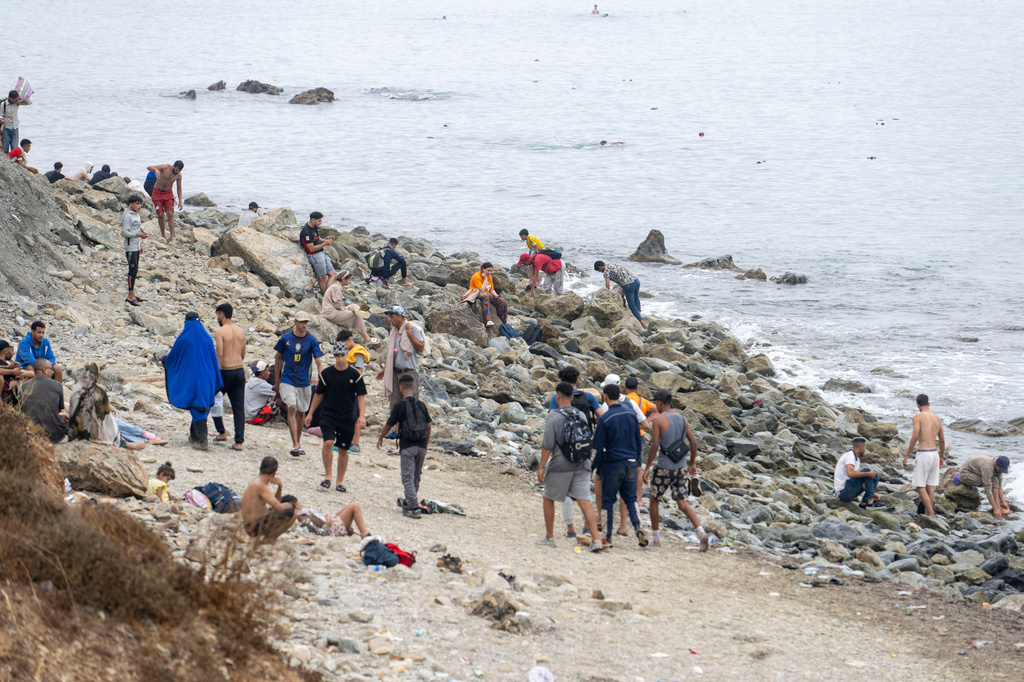 People walk on the beach as they attempt to cross from the Moroccan northern town of Fnideq to the Spanish enclave of Ceuta, Friday, July 31, 2026. (AP Photo)
