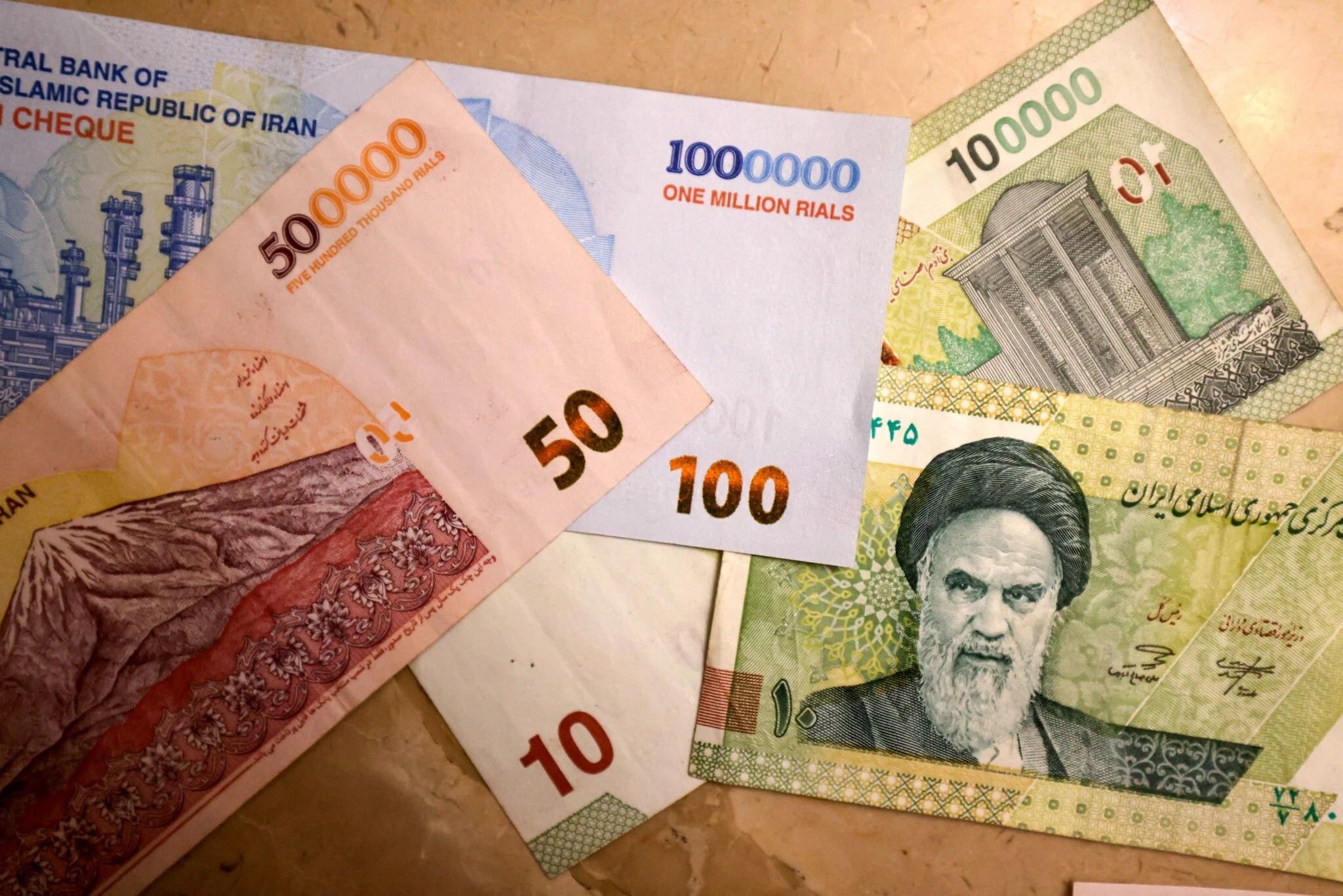 This picture shows new Iranian bank notes of 1 million, 500,000, and 100,000 rials on August 3, 2025. (ATTA KENARE / AFP)
